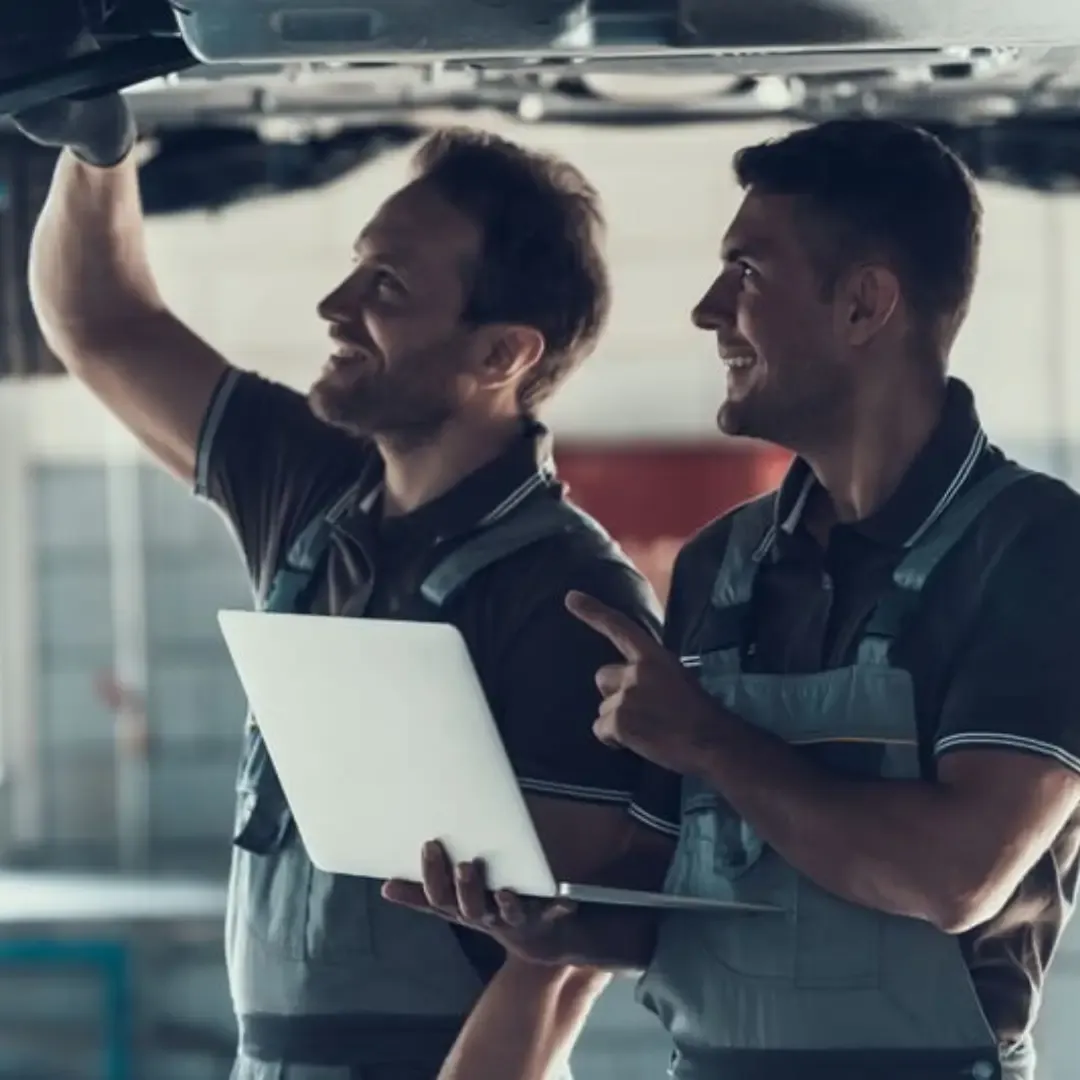Two male mechanics with a car on the ramp in a MOT service centre in Longwell Green Bristol.