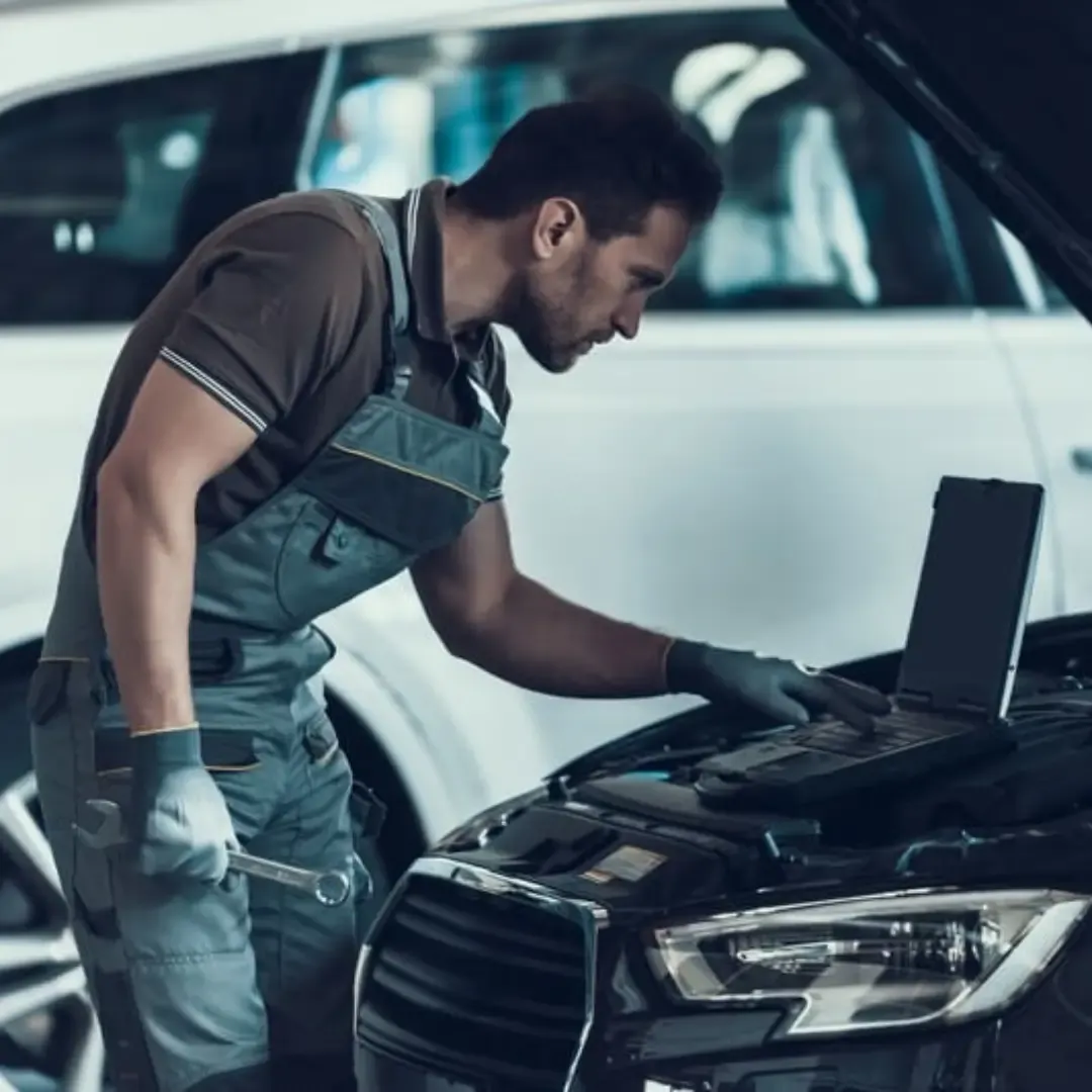 Mechanic working on a car at an MOT centre in London.